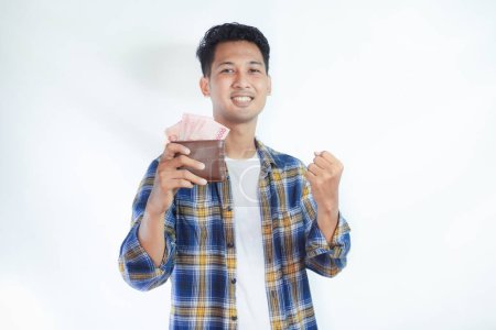 Foto de Adulto asiático hombre mostrando excitado expresión de la cara mientras sostiene su cartera llena de dinero - Imagen libre de derechos