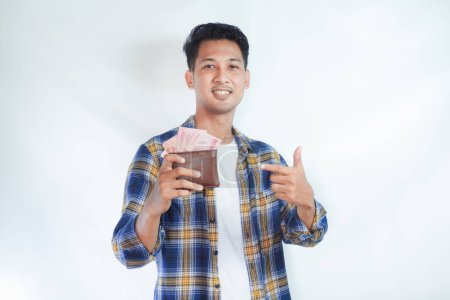 Foto de Adulto asiático hombre sonriendo mientras señala el dinero que él sostiene - Imagen libre de derechos