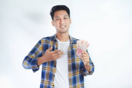 Foto de Adulto asiático hombre sonriendo mientras señala el dinero que él sostiene - Imagen libre de derechos