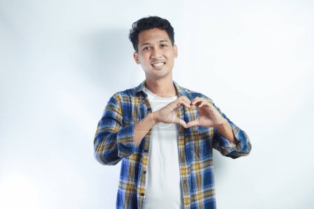 Foto de Adulto asiático hombre sonriendo feliz mientras que hacer corazón forma símbolo con sus manos - Imagen libre de derechos