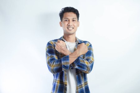 Adulte asiatique homme faire signe de croix avec sa main avec expression heureuse