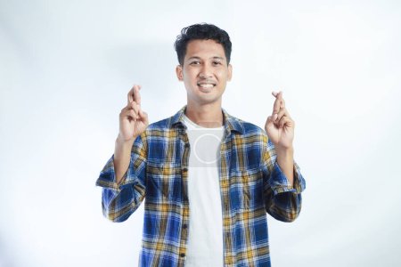 Asiatique homme portant chemise faire signe de croix avec heureuse expression faciale