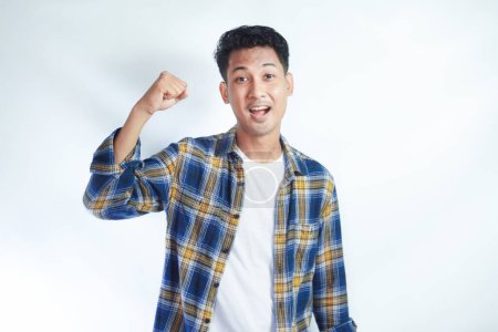 Adult Asian man screaming success with his fist clenched