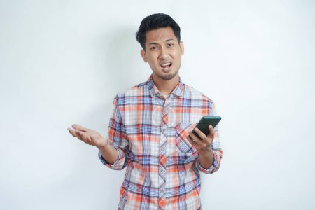Adulte asiatique homme montrant expression déçue tout en tenant téléphone mobile