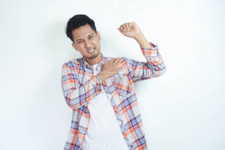 Erwachsener asiatischer Mann berührt seine linke Schulter mit Schmerzausdruck