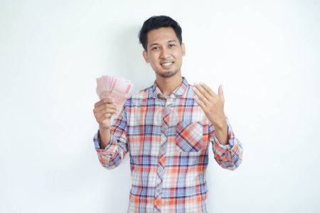 Erwachsener asiatischer Mann lächelt glücklich in die Kamera, während er Geld hält