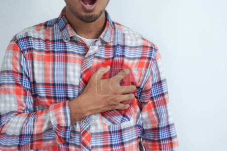 Photo for Young man having heart ache, holding hand on chest. Heart attack or stroke. risk of coronary heart disease, diabetes, high blood pressure hyperlipidemia. Pain points are highlighted in red. isolated. - Royalty Free Image