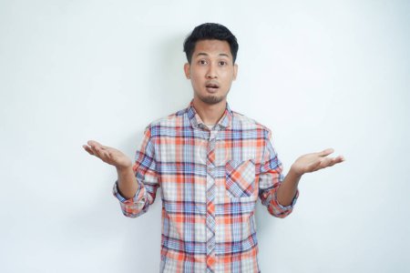Erwachsener asiatischer Mann zeigt verwirrten Gesichtsausdruck mit beiden Händen und macht unausgewogene Geste