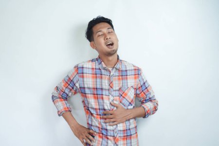 Photo for Adult Asian man touching his belly with relieved expression - Royalty Free Image