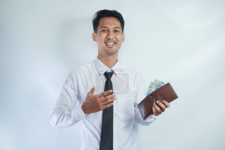 Foto de Adulto asiático hombre sonriendo feliz mientras muestra su cartera llena de papel moneda - Imagen libre de derechos