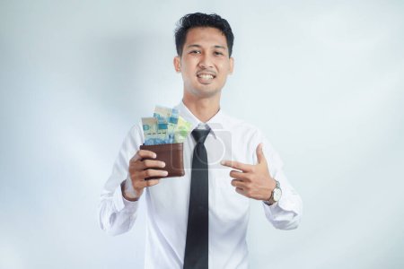 Adult Asian man smiling happy while showing his wallet full of paper money