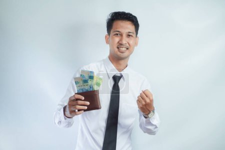 adulte asiatique l'homme montrant excité visage expression tout en tenant son portefeuille plein d'argent