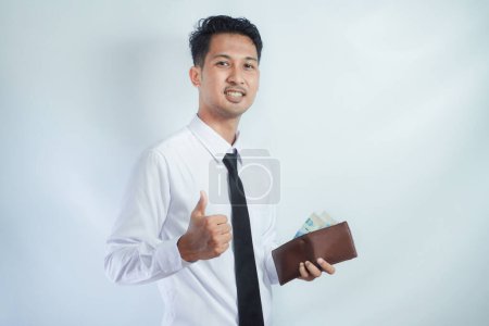 Foto de Asiático hombre de negocios sonriendo y dar pulgar hacia arriba mientras sostiene el dinero - Imagen libre de derechos