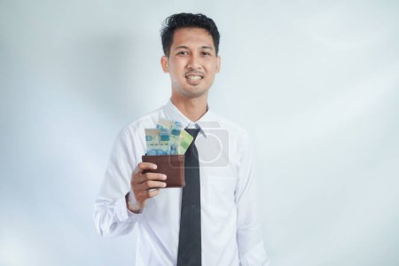 Erwachsener asiatischer Mann lächelt glücklich, während er sein Portemonnaie voller Papiergeld zeigt