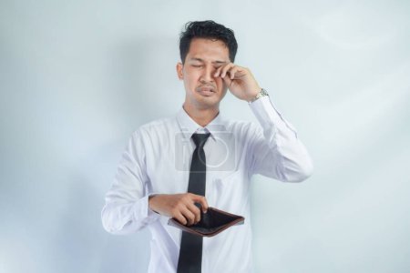Adult Asian man showing his empty wallet with worried expression