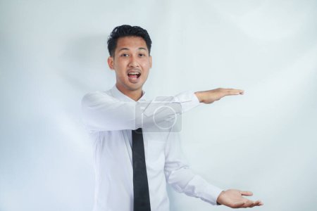 Photo for Adult Asian man smiling happy with both hand doing holding something pose - Royalty Free Image