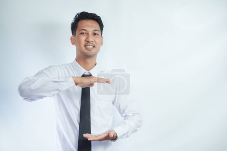 Photo for Adult Asian man smiling happy with both hand doing holding something pose - Royalty Free Image