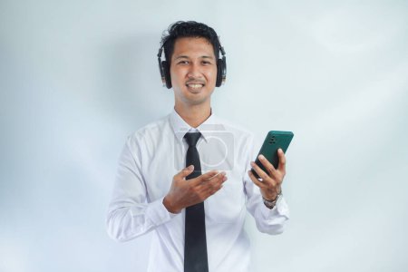 Schöner asiatischer Mann hört Musik mit Handy und drahtlosem Headset