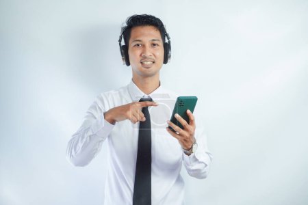 Schöner asiatischer Mann hört Musik mit Handy und drahtlosem Headset