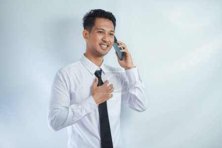 Erwachsener asiatischer Mann lächelt glücklich, wenn er mit jemandem telefoniert