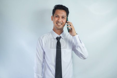 Erwachsener asiatischer Mann lächelt glücklich, wenn er mit jemandem telefoniert