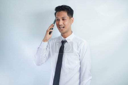 Adulto asiático hombre sonriendo feliz al llamar con alguien