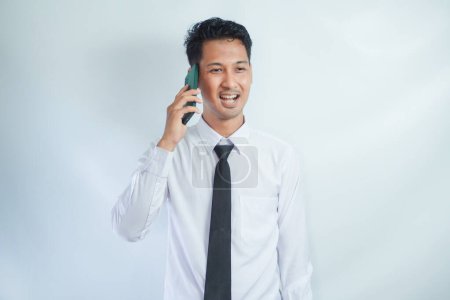 Adulto asiático hombre sonriendo feliz al llamar con alguien