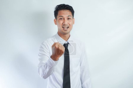 Photo for Young Asian business man showing happy excited expression with clenched fist - Royalty Free Image