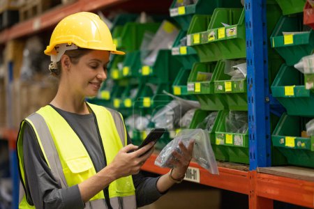 Photo for Warehouse worker tag and label products with a handheld scanner to prepare and complete orders. Verifying all products are safely and securely packed and labeled for shipment to the correct location. - Royalty Free Image