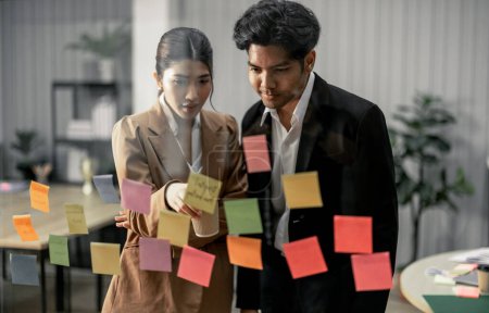 Photo for Businessperson discuss, exchange ideas and develop fresh perspectives by using sticky notes. Working collaboratively as a team help generate innovative ideas and potential solutions for the company. - Royalty Free Image