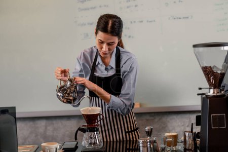 Photo for Young adult baristas follow recipes to create artisan and specialty beverages. Making drip coffee with a unique way. Small business owners practice the sense of taste and scent at slow bar coffee. - Royalty Free Image