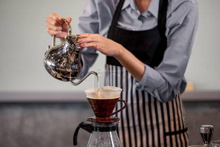 Photo for Young adult baristas follow recipes to create artisan and specialty beverages. Making drip coffee with a unique way. Small business owners practice the sense of taste and scent at slow bar coffee. - Royalty Free Image