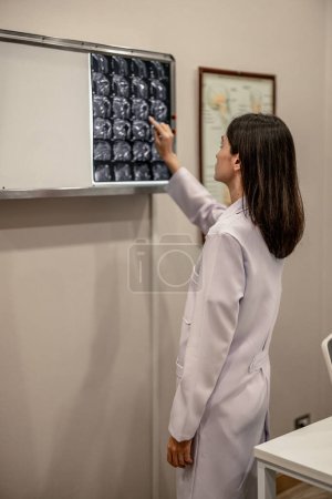 Téléchargez les photos : Le médecin et le radiologue analysent les images médicales, y compris le film d'IRM, pour identifier l'état du patient afin d'élaborer des plans de traitement et de futures procédures médicales, orientent les patients vers des spécialistes. - en image libre de droit