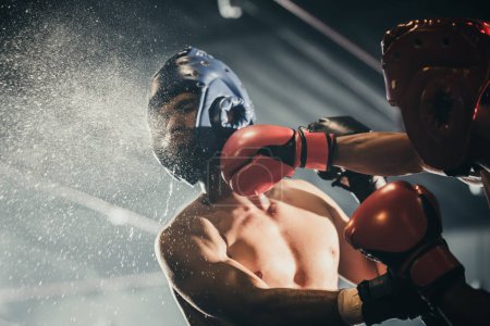 Photo for Boxer use various punch combinations, including the jab, hook, uppercut, cross, swing, straight. Getting in close to make opponent on ropes and knockout. Boxing champions win the round in boxing ring - Royalty Free Image