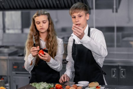 Photo for Teenagers learn from expert chefs at culinary school to prepare ingredients and create a variety of tasty meals. A practical activity connected their senses of taste and smell is making hamburgers. - Royalty Free Image
