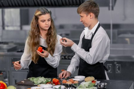 Photo for Teenagers learn from expert chefs at culinary school to prepare ingredients and create a variety of tasty meals. A practical activity connected their senses of taste and smell is making hamburgers. - Royalty Free Image
