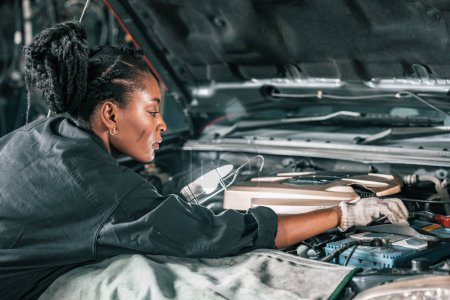 Photo for Experienced auto mechanics inspect car battery terminals and voltage to identify the cause of errors or defects. Perform diagnosis, repair, replace, and remove mechanical and electrical components. - Royalty Free Image