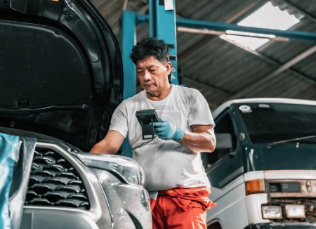 Photo for Experienced auto mechanics inspect car battery terminals and voltage to identify the cause of errors or defects. Perform diagnosis, repair, replace, and remove mechanical and electrical components. - Royalty Free Image
