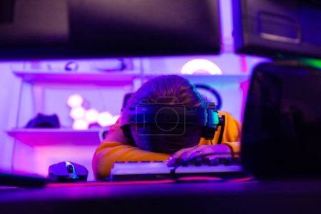 Photo for After a lengthy period of practice, professional gamer always get neck, shoulder, back, finger pain. Tired, exhausted ,sleepy are results of repetitive activity. Pro-gamer suffer from office syndrome - Royalty Free Image
