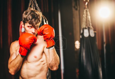 Foto de Los boxeadores a nivel profesional entrenan rutinariamente golpeando y pateando sacos de arena. Tener éxito en la carrera del individuo, la autodisciplina, la determinación y la paciencia son cualidades esenciales.. - Imagen libre de derechos