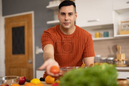 Photo for A homely and healthy male prepares nutritious diet, including variety of fruits. Following cooking show on laptop Mastery of peeling, chopping, and slicing fruits to prepare them in artistic style. - Royalty Free Image