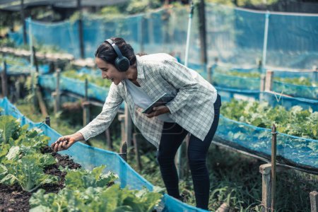 Foto de Los trabajadores agrícolas mejoran el equilibrio entre el trabajo y la vida al escuchar música y mover el cuerpo al ritmo y ritmo. Diseño de horarios de trabajo flexibles, descansos, recarga de energía y vitalidad - Imagen libre de derechos