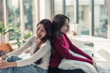 Photo for A Lesbian is annoyed, frustrated because her partner ignores and doesn't pay attention to her. Couples' conflicts make atmosphere tense and stressed. Misunderstanding can destroys relationships. - Royalty Free Image