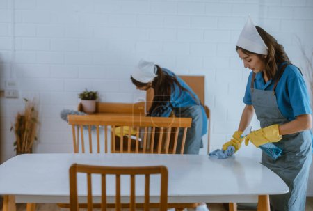 Photo for Enthusiastic house cleaning lady do various tasks with responsibility. Using mop, broom, laundry machine, cleaning supplies to wipe, scrub, and dust furniture, glassware, floors, clothes, dishes. - Royalty Free Image