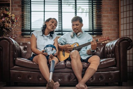 Photo for Husband strums guitar and his wife sings songs, creating joyful, romantic atmosphere in the free time. The bond grows stronger through music. Carefree, intimate moment filled with happiness and ease. - Royalty Free Image