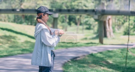 Photo for Fashionable female runners dressed in modern gear, finds peace in rhythmic beats. Recharge energy in the midst of life's steady, serene flow. Embrace tranquility while jogging through public parkway. - Royalty Free Image