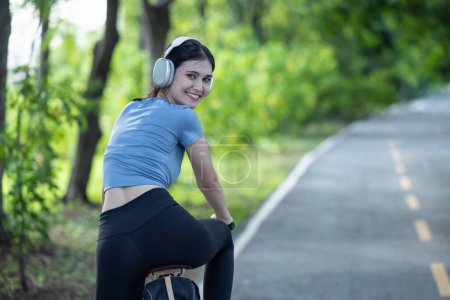 Photo for Female cyclist combine eco-consciousness with active lifestyle, using bikes for workout and travel, a portable solar panel for device charging, and embracing recycling practices for circular economy. - Royalty Free Image