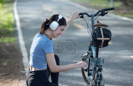 Photo for Female cyclist combine eco-consciousness with active lifestyle, using bikes for workout and travel, a portable solar panel for device charging, and embracing recycling practices for circular economy. - Royalty Free Image