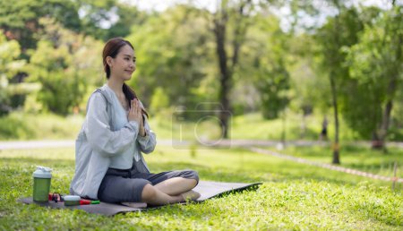 Téléchargez les photos : Jeune femme asiatique adulte découvre la revitalisation en s'engageant dans des pratiques de yoga et de méditation dans le parc. Harmoniser les capacités physiques et mentales Restaurer les niveaux d'énergie, la vitalité globale et le bien-être - en image libre de droit