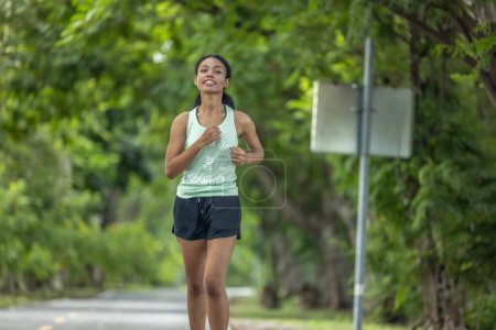 Photo for Fashionable female runners dressed in modern gear, finds peace in rhythmic beats. Recharge energy in the midst of life's steady, serene flow. Embrace tranquility while jogging through public parkway. - Royalty Free Image